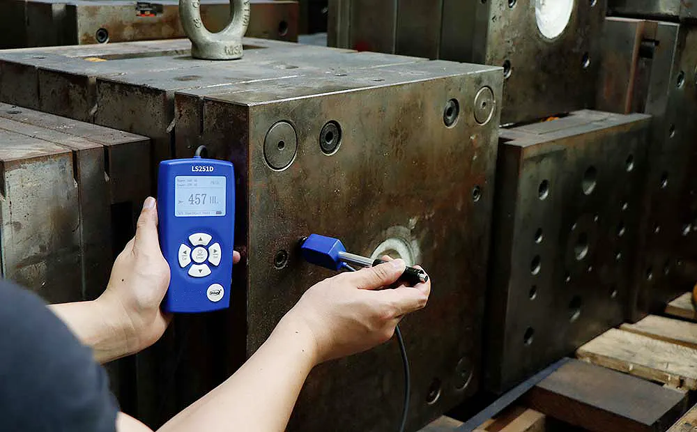 Technician inspecting a used power press clutch and brake assembly
